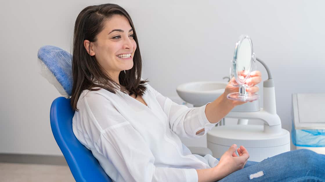 Woman Admiring Smile in Mirror