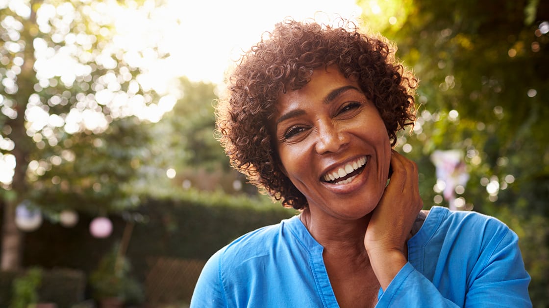 Mature woman with beautiful smile at Sunset